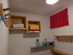 a bathroom with a sink and a red window and towels at Baita Nido tra i Monti in Daone +24 photos