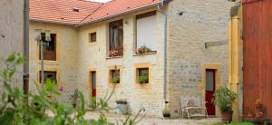 a stone building with potted plants on the windows at A La Cour Basse in Peltre