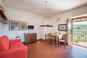 a living room with a red couch and a table at Podere del Pereto Bio- 201 in Rapolano Terme
