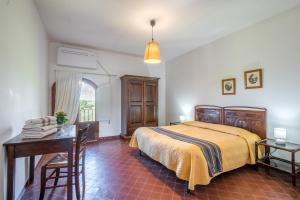 a bedroom with a bed and a table and a desk at Podere del Pereto Bio- 201 in Rapolano Terme +20 photos
