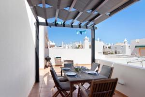 a dining room with a table and chairs on a balcony at Quinta Gomeira 146 in Cabanas de Tavira