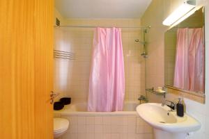 a bathroom with a pink shower curtain and a sink at Quinta Gomeira 146 in Cabanas de Tavira +12 photos