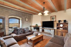 a living room with couches and a flat screen tv at Cal Cirera in Sagás