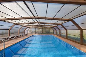 an indoor swimming pool with a glass ceiling at Cal Cirera in Sagás