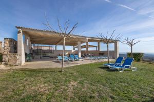 a group of blue lounge chairs sitting on the grass at Cal Cirera in Sagás