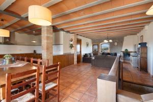 a dining room and living room with a table and chairs at Cal Cirera in Sagás