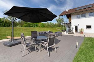a patio with a table and chairs and an umbrella at Gästesuite mit Sauna in Kehl am Rhein