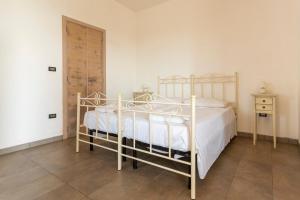 ein Schlafzimmer mit einem weißen Bett und einer Holztür in der Unterkunft Muma House in Otranto