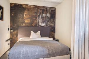 a bedroom with a bed with a stone wall at Ferienwohnung Zwei in Saal