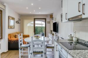 a kitchen and living room with a table and chairs at Set Cases in L'Escala