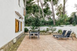 a patio with chairs and a table and a fence at Set Cases in L'Escala