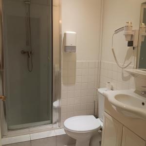 a bathroom with a shower and a toilet and a sink at Hotel Wilson Square in Toulouse