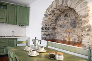 a kitchen with a table and a stone wall at Emilia's Lakeview Terrace in Brienno +7 photos