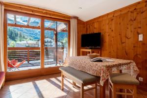 a dining room with a table and a large window at Naturidyll Mitterbach in Rio Bianco