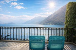 two chairs sitting on a balcony overlooking a body of water at Emilia's Lakeview Terrace in Brienno