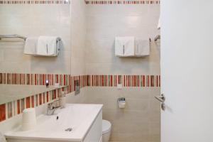 a white bathroom with a sink and a toilet at Townhouse Ramas in Vale do Lobo +15 photos