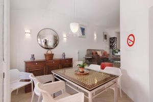 a dining room with a table and white chairs at Townhouse Ramas in Vale do Lobo