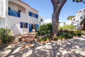 a tree in front of a white building at Townhouse Ramas in Vale do Lobo