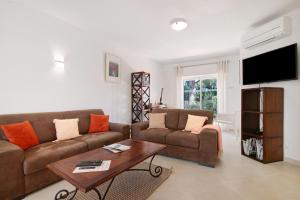 a living room with a couch and a table at Townhouse Ramas in Vale do Lobo