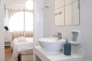 a white bathroom with a sink and a bed at Livadia Seaside Studios 8 in Parikia