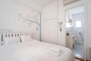 a white bedroom with a bed and a bathroom at Livadia Seaside Studios 8 in Parikia