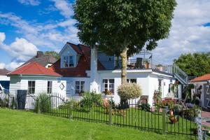 a white house with a fence at Weitblick in Wesselburen
