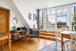 a living room with a table and chairs and a window at Weitblick in Wesselburen +21 photos