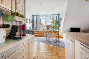 a kitchen with white cabinets and a dining room with a table at Weitblick in Wesselburen