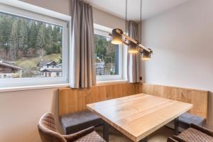 a dining room with a wooden table and two chairs at Luisalle Top 1 in Auffach