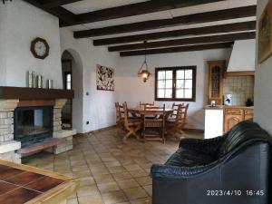 ein Wohnzimmer mit Kamin, Tisch und Stühlen in der Unterkunft Maison de vacances Diff in Puttelange-aux-Lacs