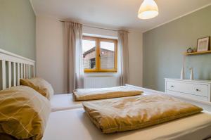 zwei Betten in einem Schlafzimmer mit Fenster in der Unterkunft Donauliebe in Sigmaringen