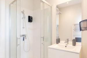 a white bathroom with a shower and a sink at Syrah in Ruoms