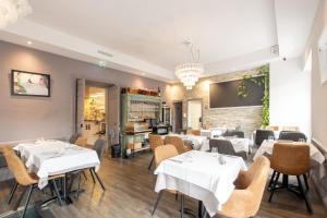 a dining room with white tables and chairs at Syrah in Ruoms