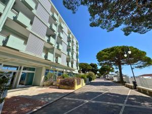 an empty sidewalk next to a building with a tree at Bruseschi Appartament in Grado