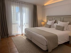 a bedroom with a large bed and a large window at Hotel Calina in Cadaqués