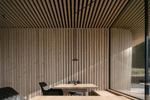 a table and chairs in a room with a wooden wall at anders mountain suites 6 in Brixen +31 photos