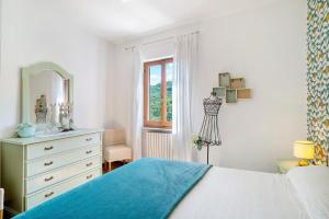a bedroom with a bed and a dresser and a window at La casa di Bosco in Casanova Lerrore