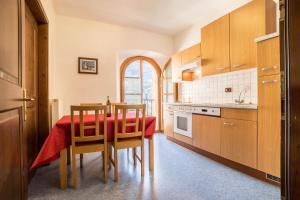 a kitchen with a table with a red table cloth on it at Residence Lena App 3 with Balcony in Tenno