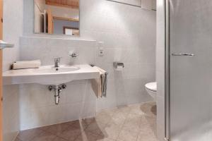 a white bathroom with a sink and a toilet at Appartement Egart 2 in Resia +26 photos