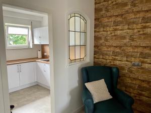 a living room with a green chair and a brick wall at Hopfenglück in Tettnang +44 photos