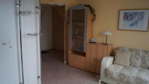 a living room with a couch and a cabinet and a mirror at Fewo Hiddensee, 2 Personen 40 M² in Wiek auf Rügen
