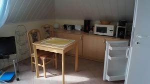 a small kitchen with a table and a microwave at Fewo Hiddensee, 2 Personen 40 M² in Wiek auf Rügen