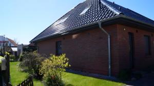 a red brick house with a black roof at Fewo Hiddensee, 2 Personen 40 M² in Wiek auf Rügen