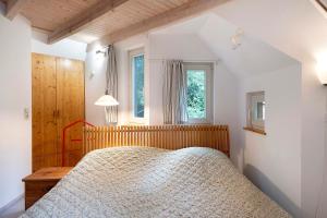 a bedroom with a bed and a window at Ferienhaus am Brandorffsee in Wiefelstede