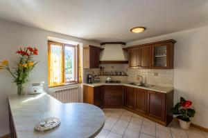 a kitchen with wooden cabinets and a table in it at Casa Rita app 1 in Tremosine Sul Garda +18 photos