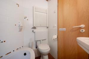 a small bathroom with a toilet and a sink at Ferienhaus am Brandorffsee in Wiefelstede +15 photos