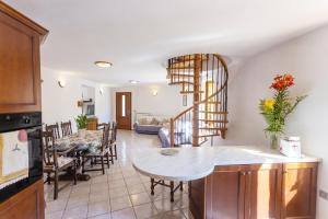 a kitchen and living room with a spiral staircase at Casa Rita app 1 in Tremosine Sul Garda