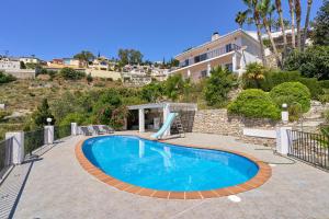 a swimming pool in front of a house at Casa Beto in Almuñécar