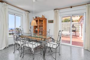 a dining room with a glass table and chairs at Casa Beto in Almuñécar