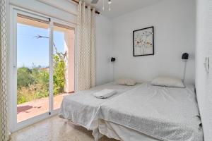 a bedroom with a bed and a large window at Casa Beto in Almuñécar +23 photos